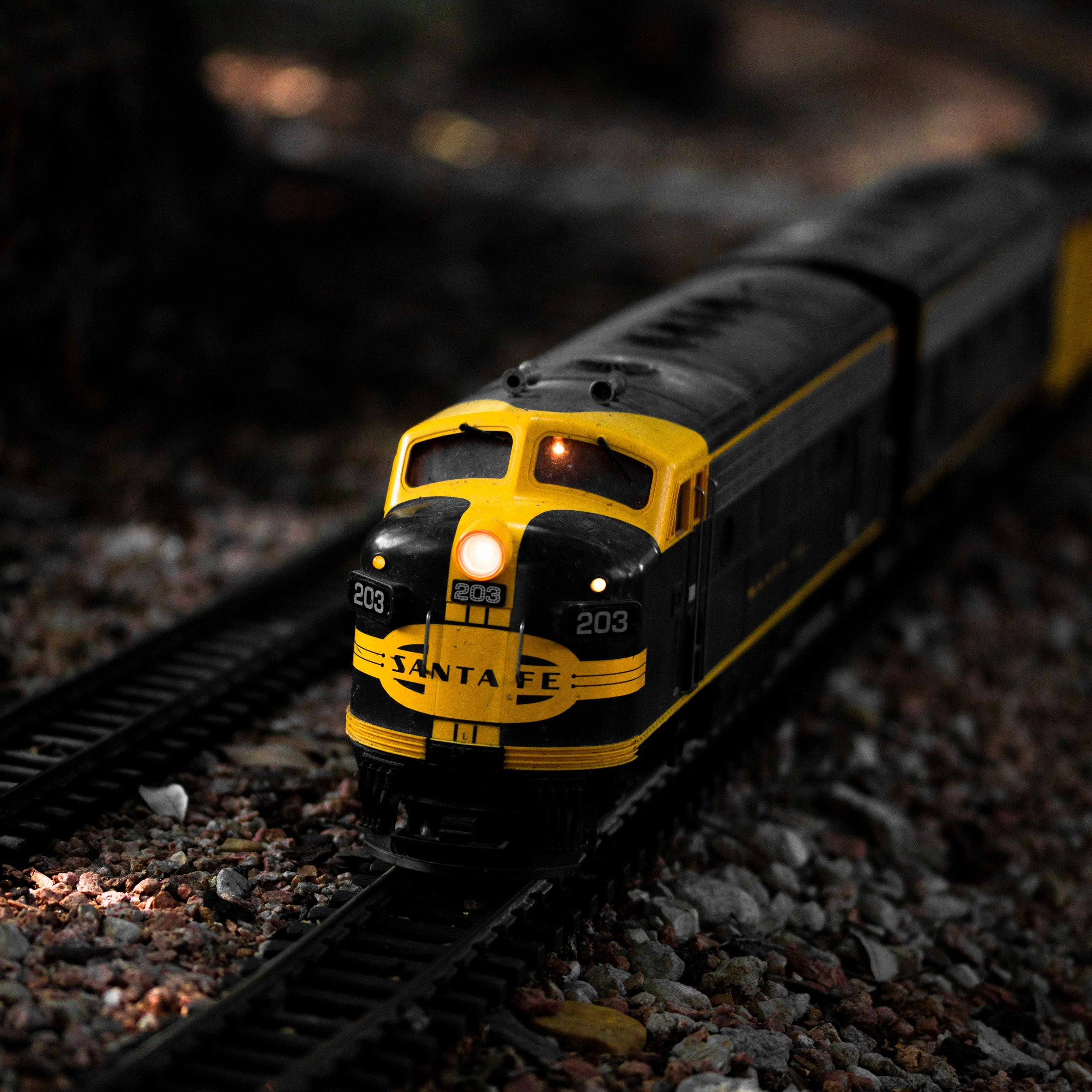 Model train engine on a track with a dark background