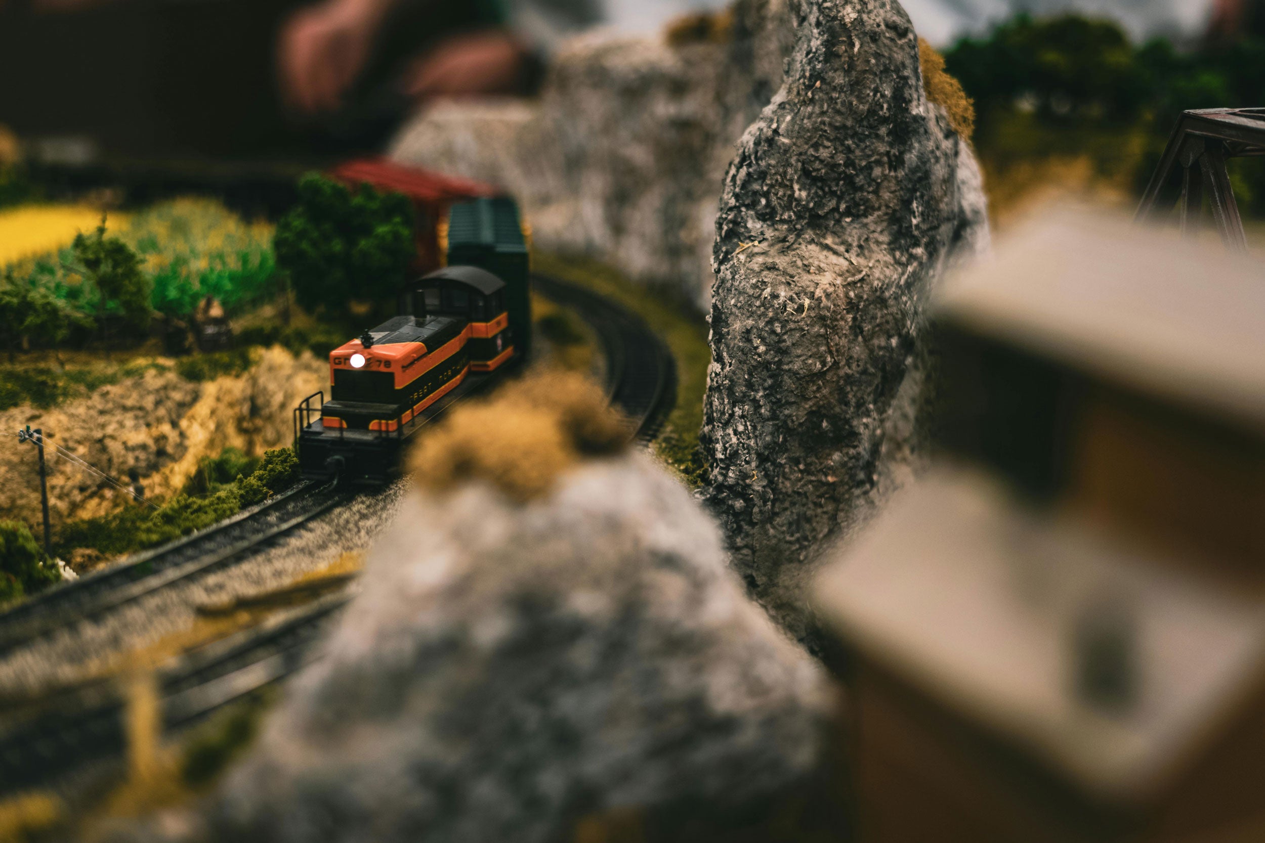 Model train on a track with a scenic background