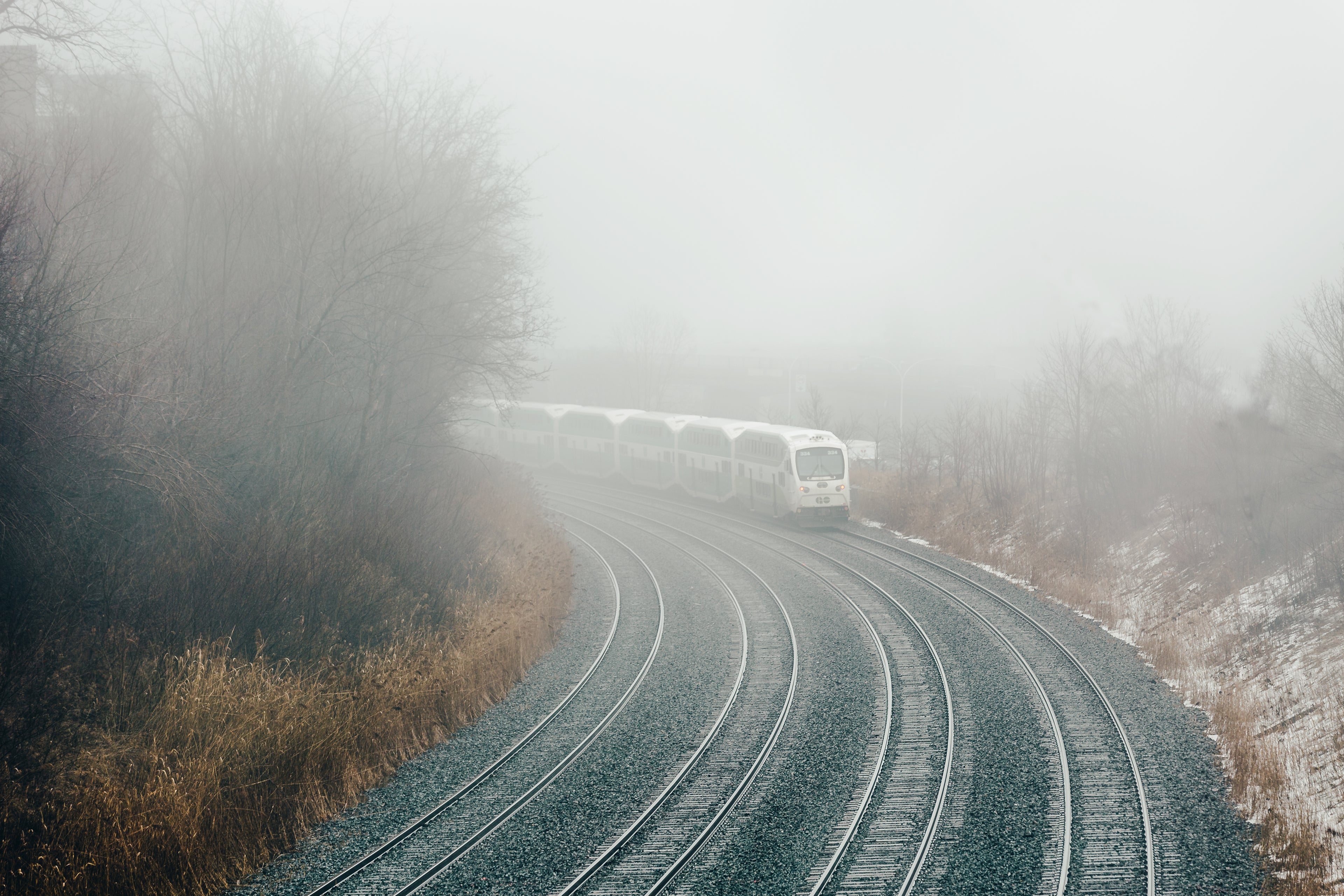 train moving around a bend in train tracks in foggy weather